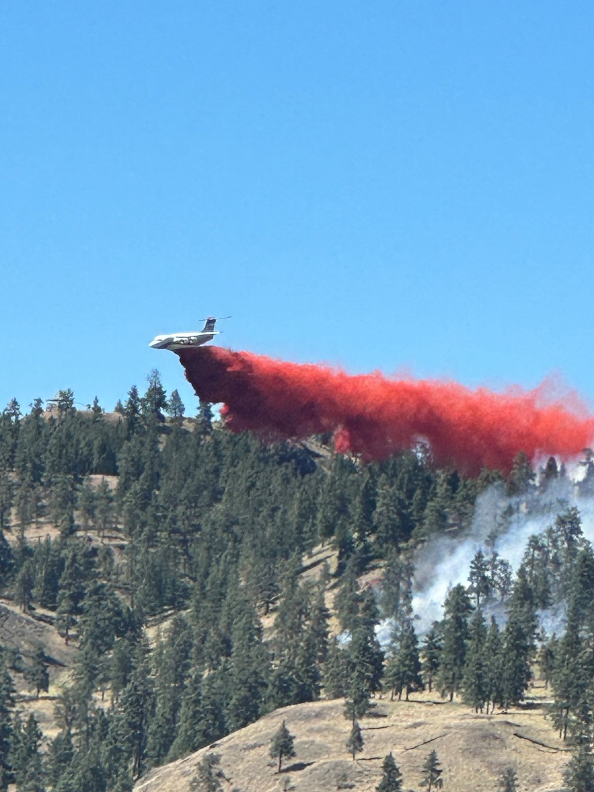 An airtanker douses the Knox Mountain Park wildfire with retardant on Saturday afternoon.