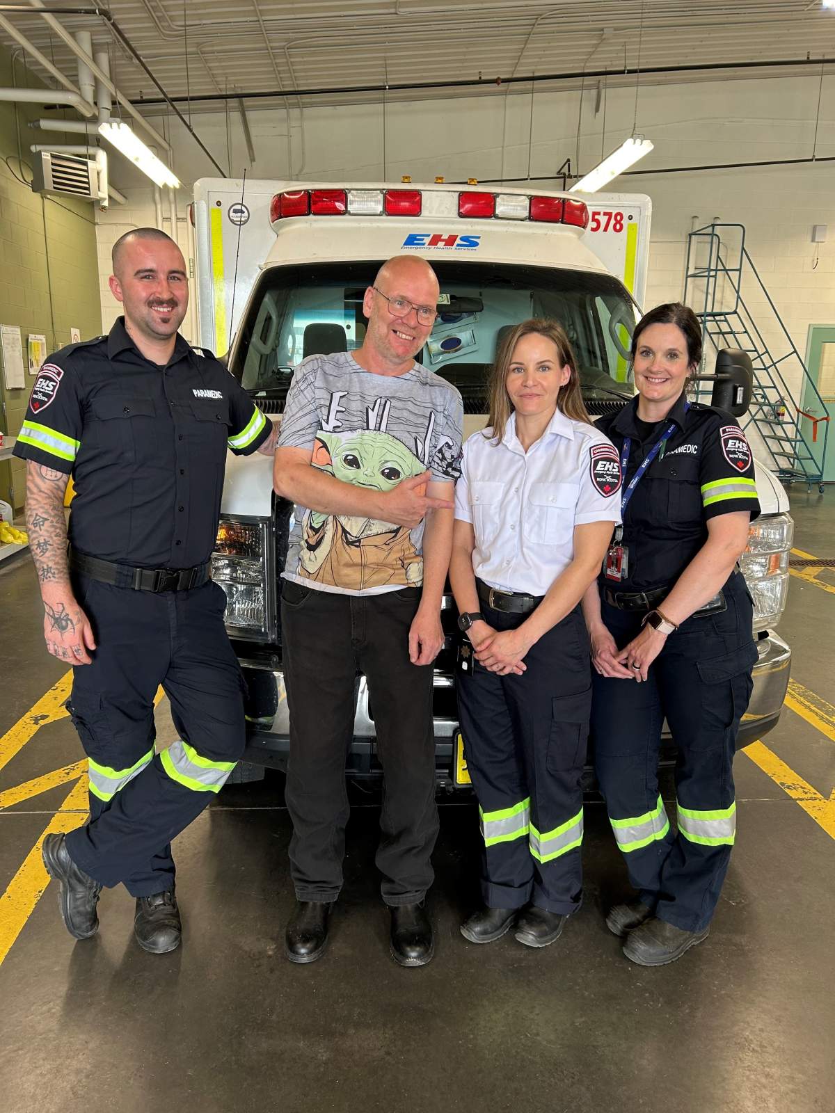 Whiteley stands alongside the paramedics and communication officer who were quick to assist during his time of need.