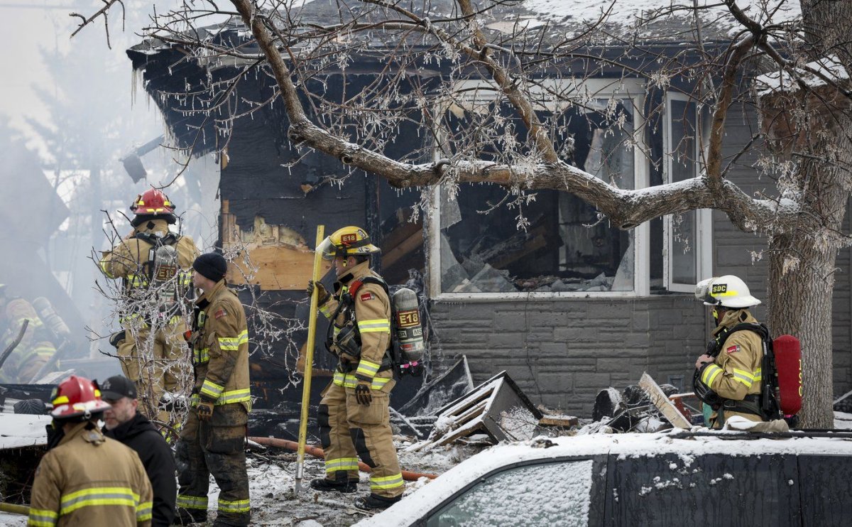 Firefighters at the scene of a house explosion that injured several people, destroyed one home and damaged others in Calgary on March 27, 2023. 