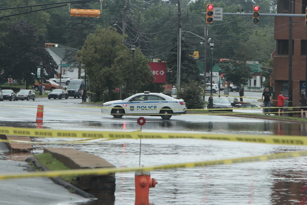 A police car blocks off a flooded road near the Bedford Place Mall.