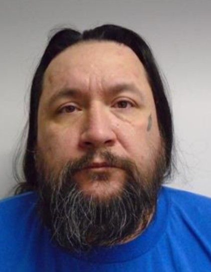 A close-up image of a man with long brown hair, a beard and mustache.