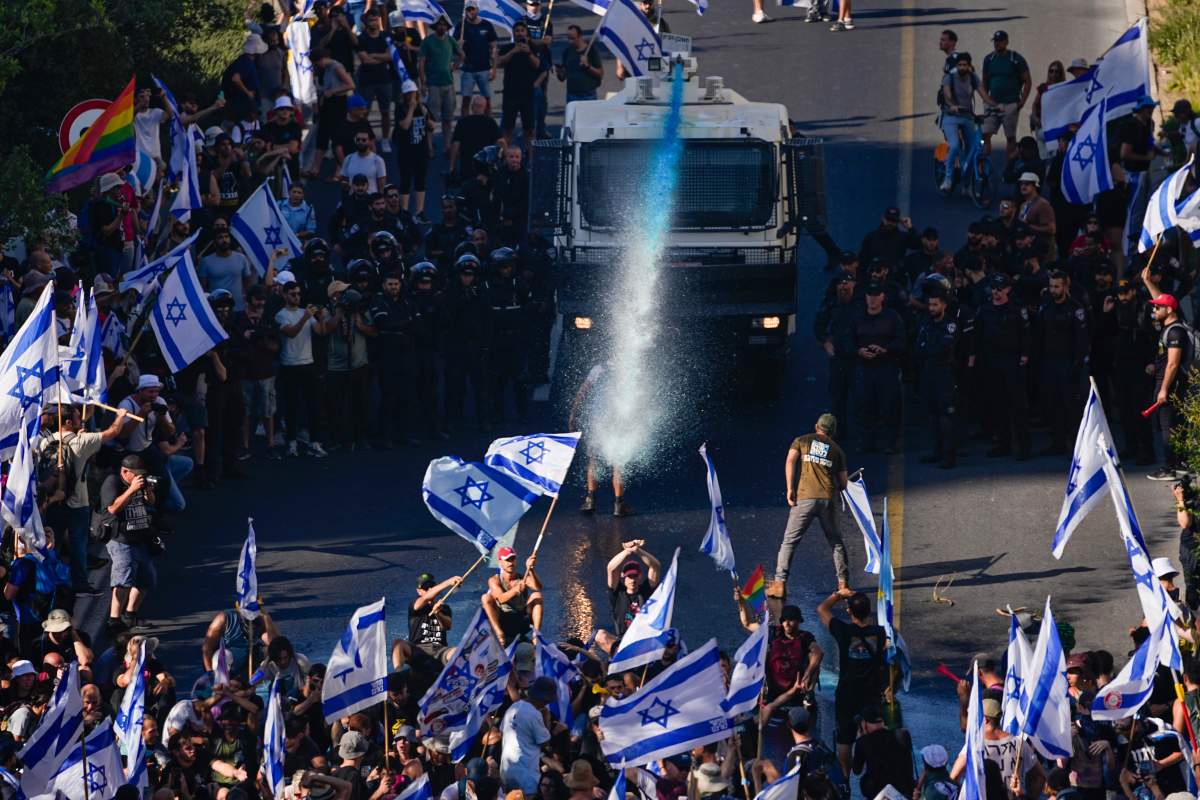 Israeli police use a water cannon to disperse demonstrators blocking a road during a protest against plans by Prime Minister Benjamin Netanyahu’s government to overhaul the judicial system, in Jerusalem, Monday, July 24, 2023. (AP Photo/Ariel Schalit)