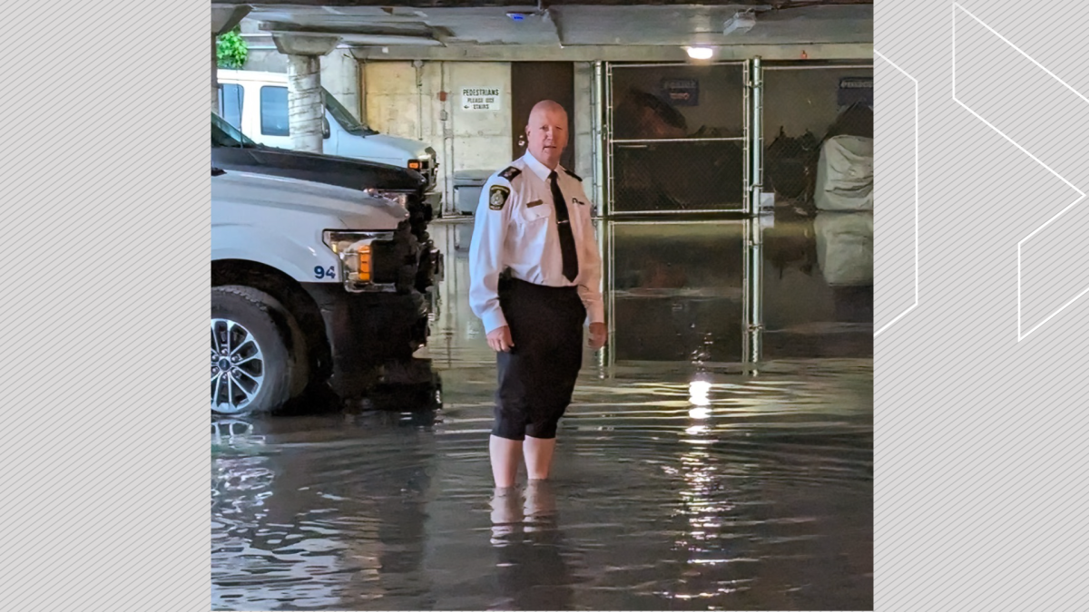 Peterborough Police Service chief Stuart Betts wades through the flooded parking lot of the police station on Water Street on July 13, 2023.