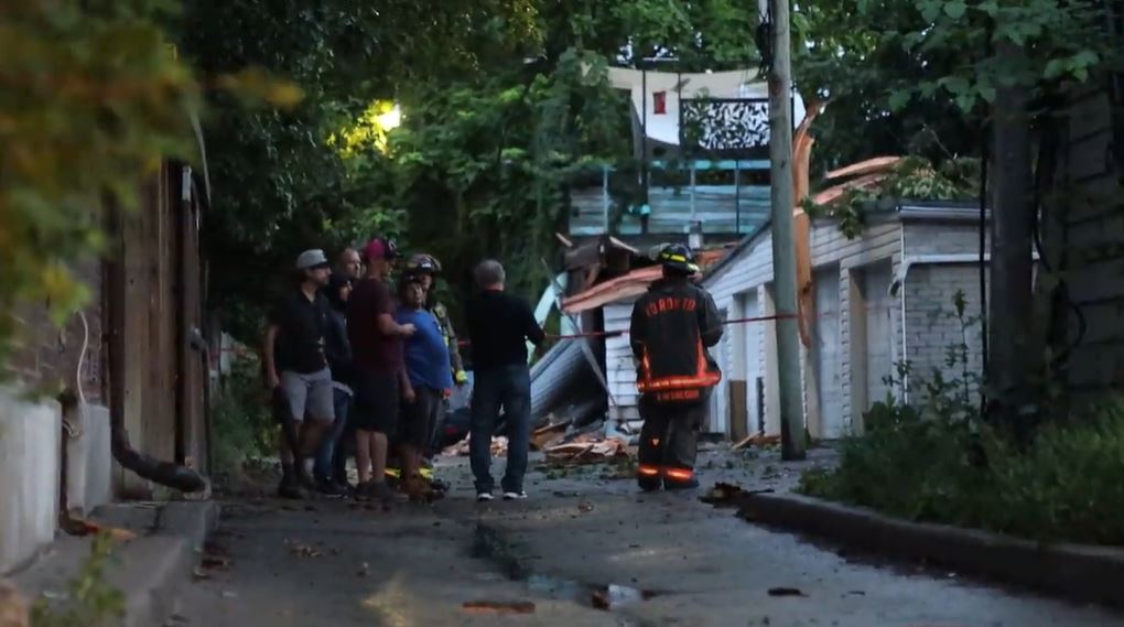 Firefighters and residents at the scene after a tree was struck by lightning in Toronto on Thursday evening.