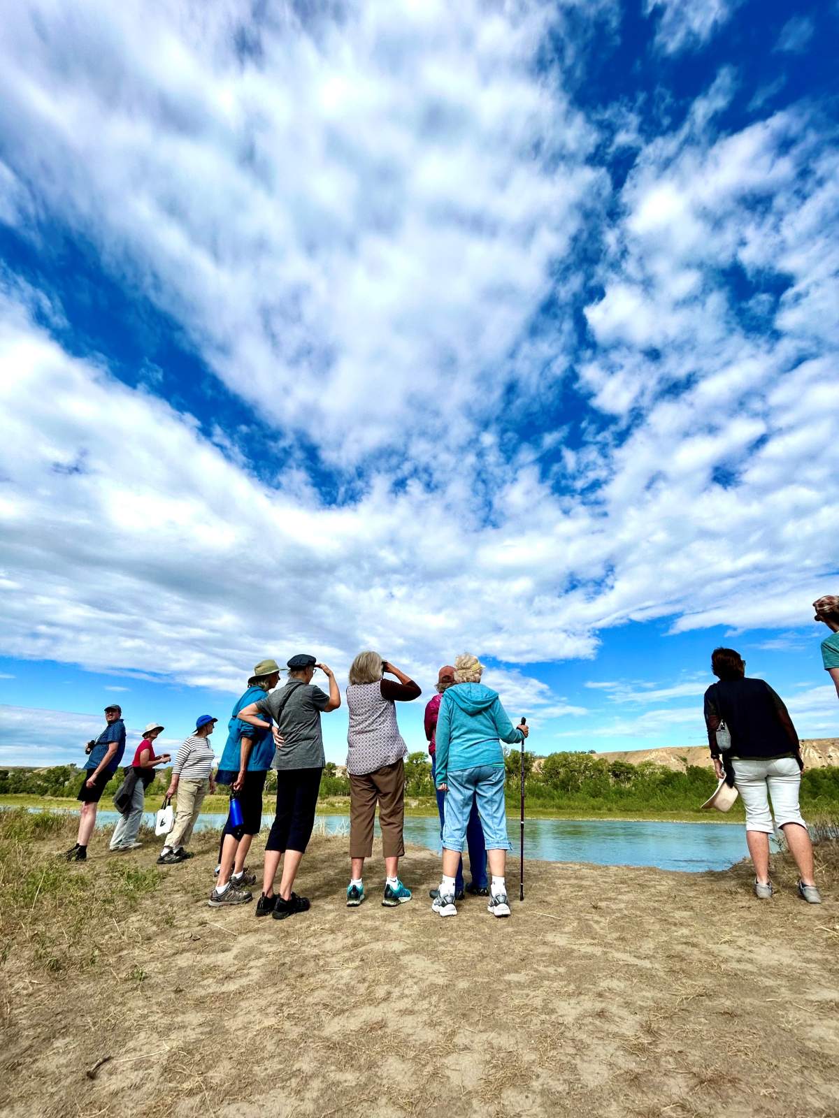 People standing along the bank of the Old Man River.
