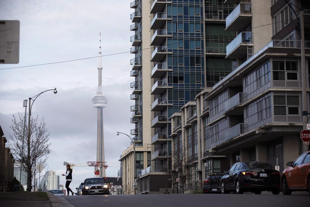 The CN Tower can be seen behind condos in Toronto's Liberty Village community on Tuesday, April 25, 2017. Urbanation Inc. says this year's Greater Toronto Area condo sales experienced their slowest first half of the year since 2013. 