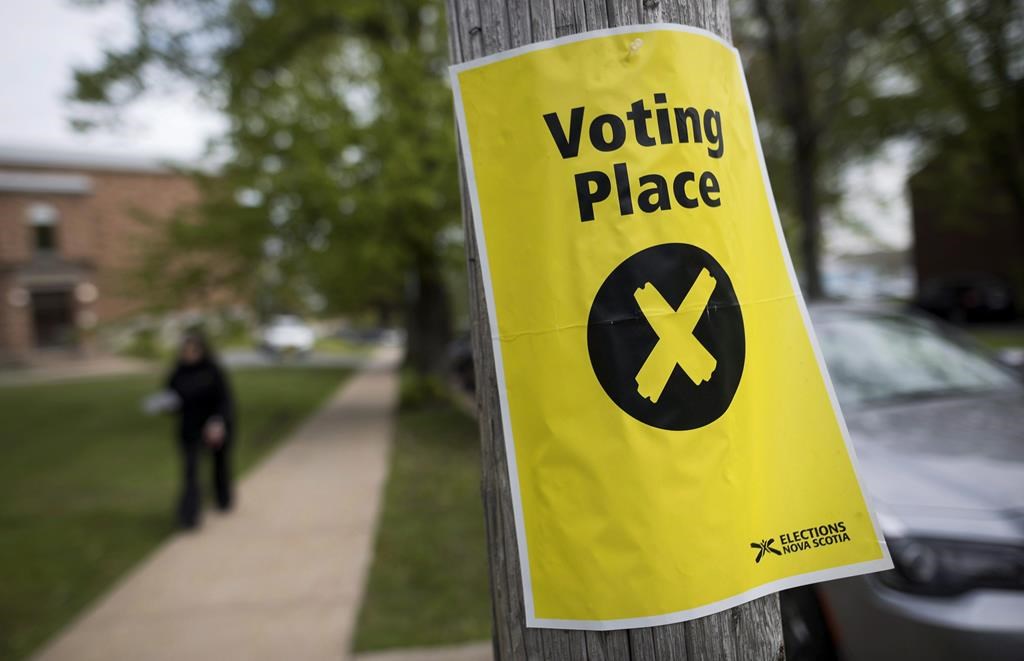 The provincial Liberal party in Nova Scotia says it is receiving unfair treatment from Elections Nova Scotia as a byelection draws to a close in the riding of Preston. A sign marking a polling station is seen as a pedestrian walks past in Halifax, on Tuesday, May 30, 2017. THE CANADIAN PRESS/Darren Calabrese