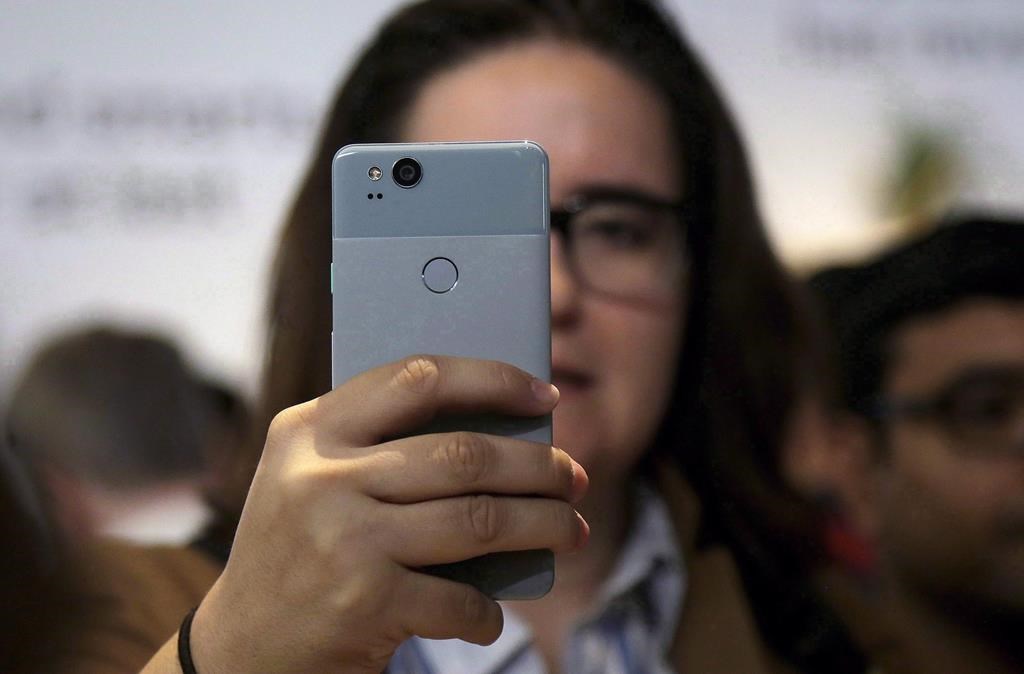 A woman looks at a Google Pixel 2 phone at a Google event at the SFJAZZ Center in San Francisco, Oct. 4, 2017.