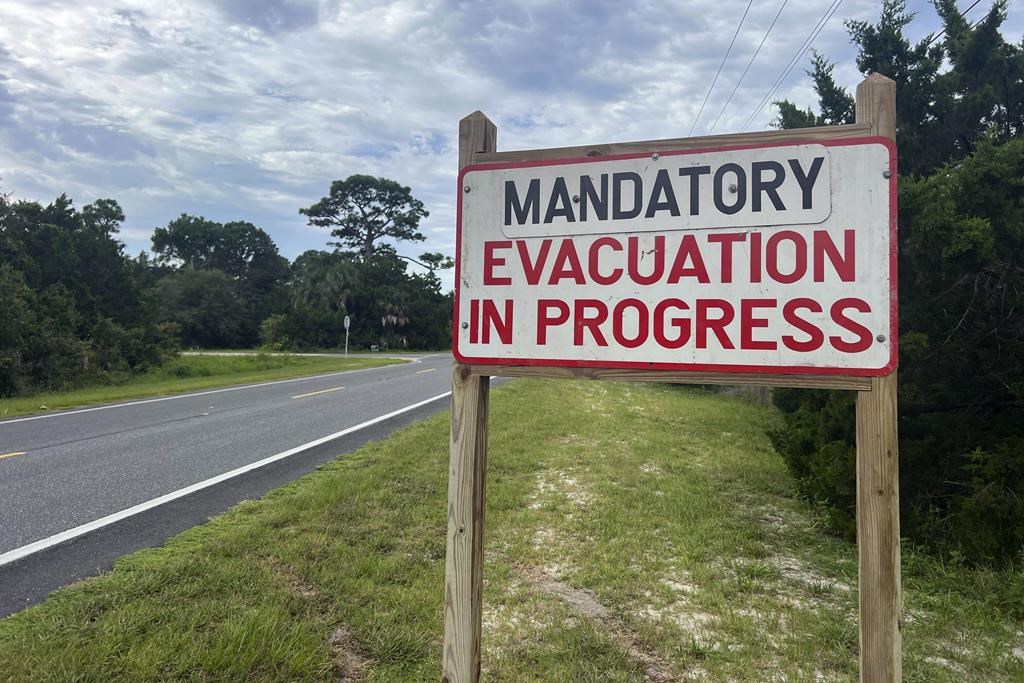 An evacuation sign stands in Cedar Key, Fla., on Tuesday, Aug. 29, 2023. Idalia strengthened into a hurricane Tuesday and barreled toward Florida’s Gulf Coast as authorities warned residents of vulnerable areas to pack up and leave to escape the twin threats of high winds and devastating flooding. (AP Photo/Daniel Kozin)