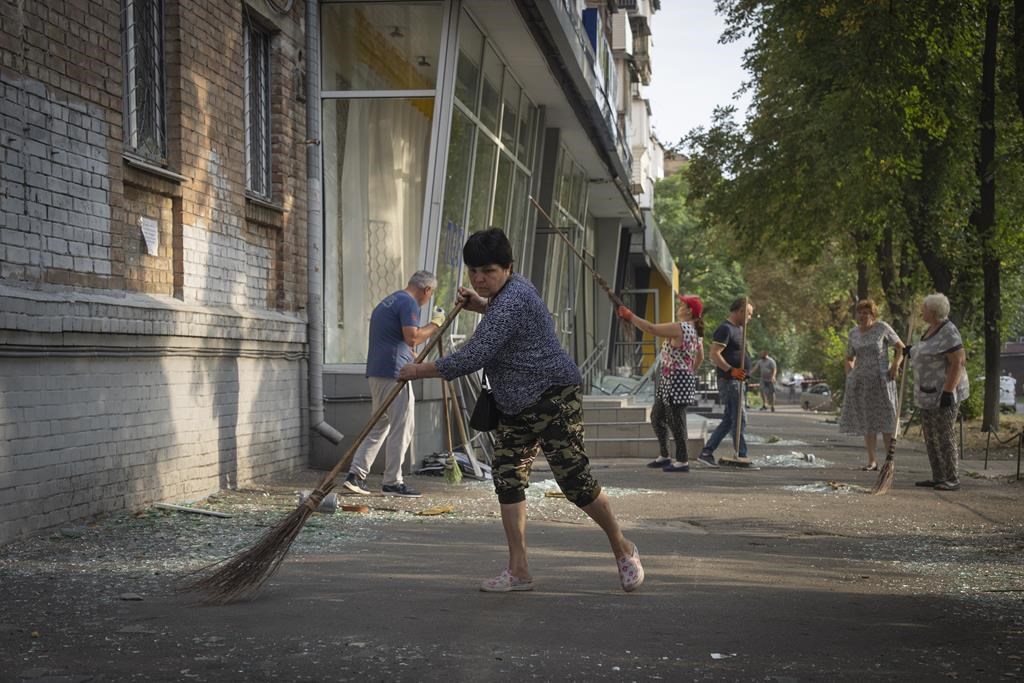 Residents clean up after Russian rocket and drone attack on Kyiv, Ukraine, Aug. 30, 2023. (AP Photo/Efrem Lukatsky)