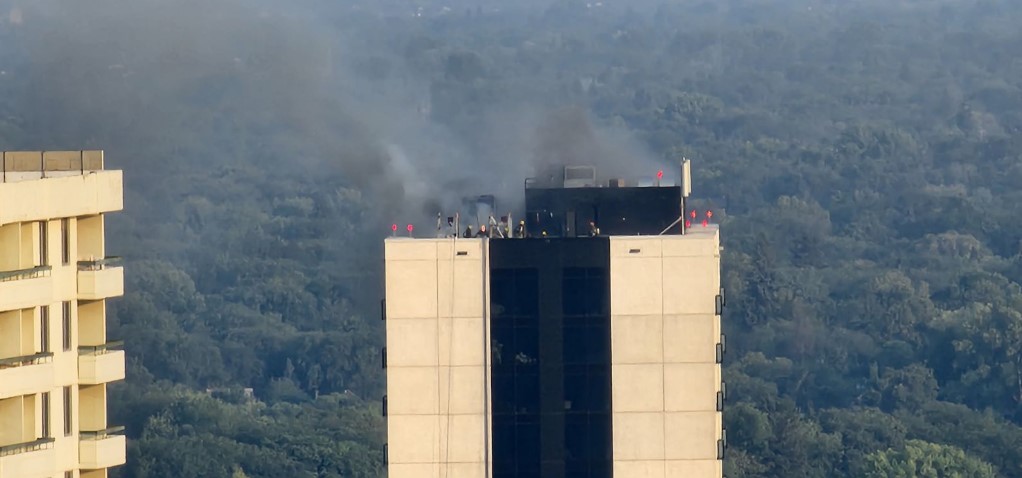 Firefighters are seen on top of the building as the flames begin to settle.