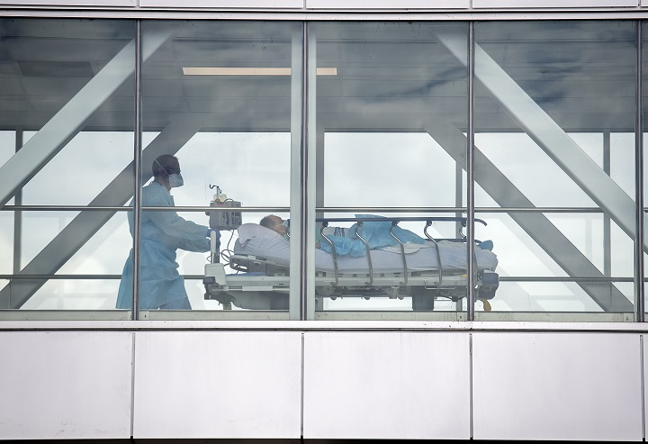 A health-care worker pushes a patient across a connecting bridge at a hospital in Montreal, Thursday, July 14, 2022.