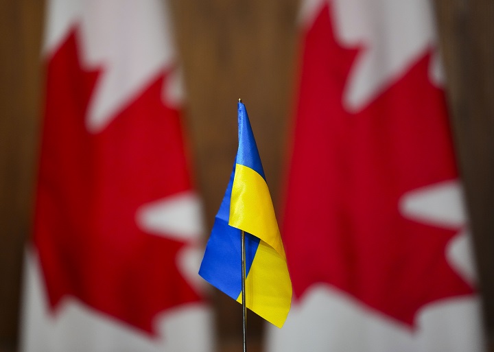 A Ukrainian flag is pictured in front of Canadian flags in Ottawa on Friday, April 1, 2022. A free new summer camp aims to help Ukrainian refugee children and their families settle in Montreal. 