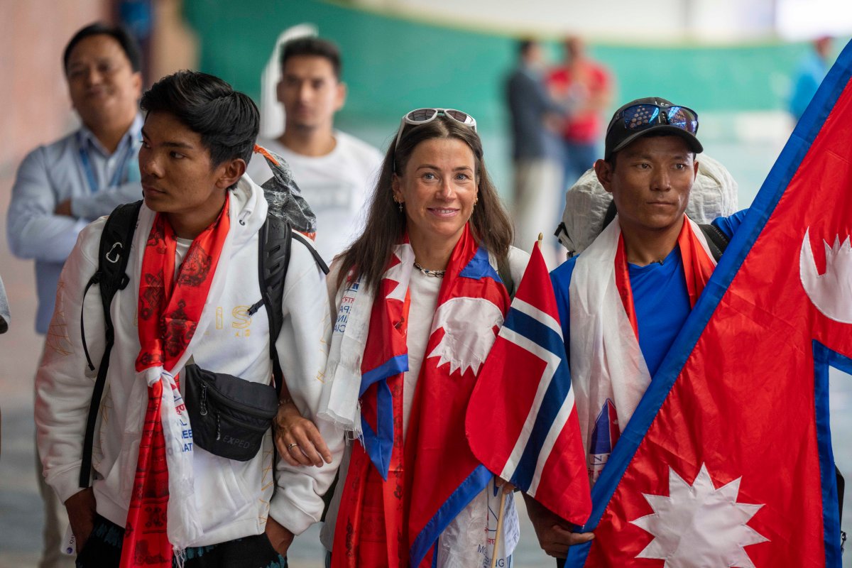 Norwegian mountain climber Kristin Harila, center and her Nepali Sherpa guide Tenjen Sherpa, right who on Thursday set a new record by scaling the world's 14 highest peaks in 92 days arrive at airport in Kathmandu, Nepal, Saturday, Aug.5, 2023.