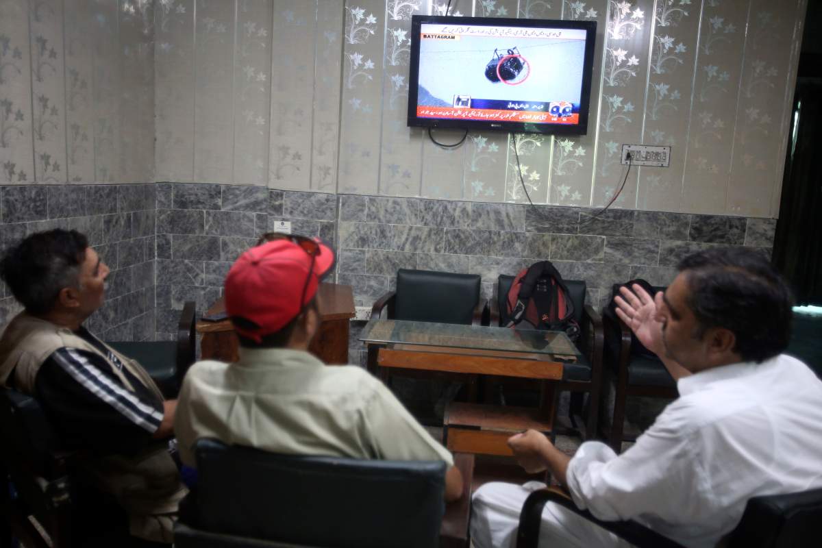 Members of media watch a news channel airing news regarding people trapped in a cable car, Tuesday, Aug. 22, 2023, at an office in Peshawar, Pakistan.