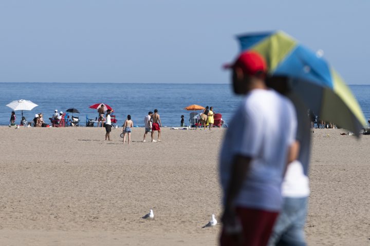 People take in the warm weather at Woodbine Beach Park in Toronto, on Tuesday, Aug. 22, 2023. 