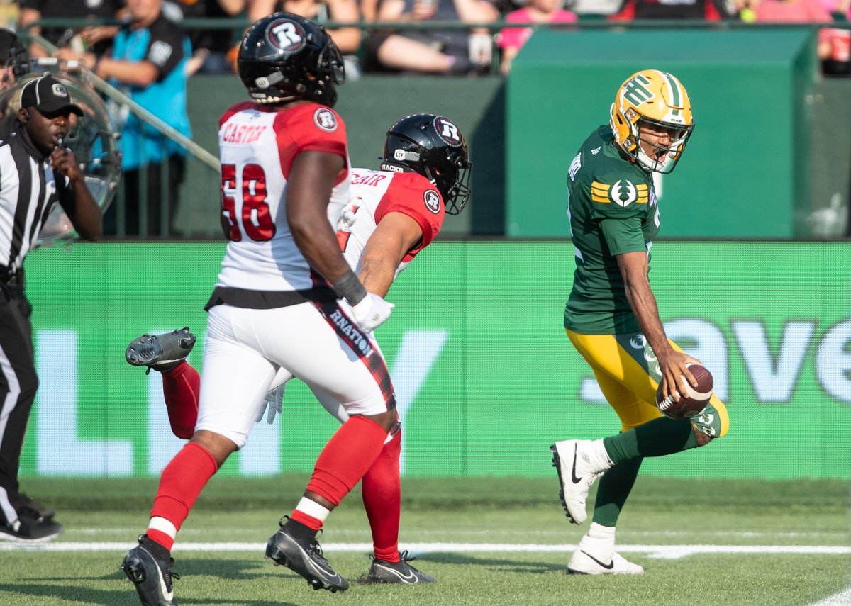 Ottawa Red Blacks' Bryce Carter (58) chases as Edmonton Elks quarterback Tre Ford (2) scores a touchdown during first half CFL action in Edmonton, Alta., on Sunday August 27, 2023.