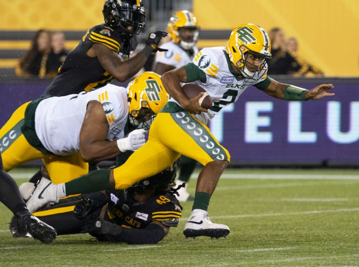 Edmonton Elks quarterback Tre Ford (2) gains some yards on the ground during CFL football game action against the Hamilton Tiger Cats in Hamilton, Ont., Thursday, Aug. 17, 2023.