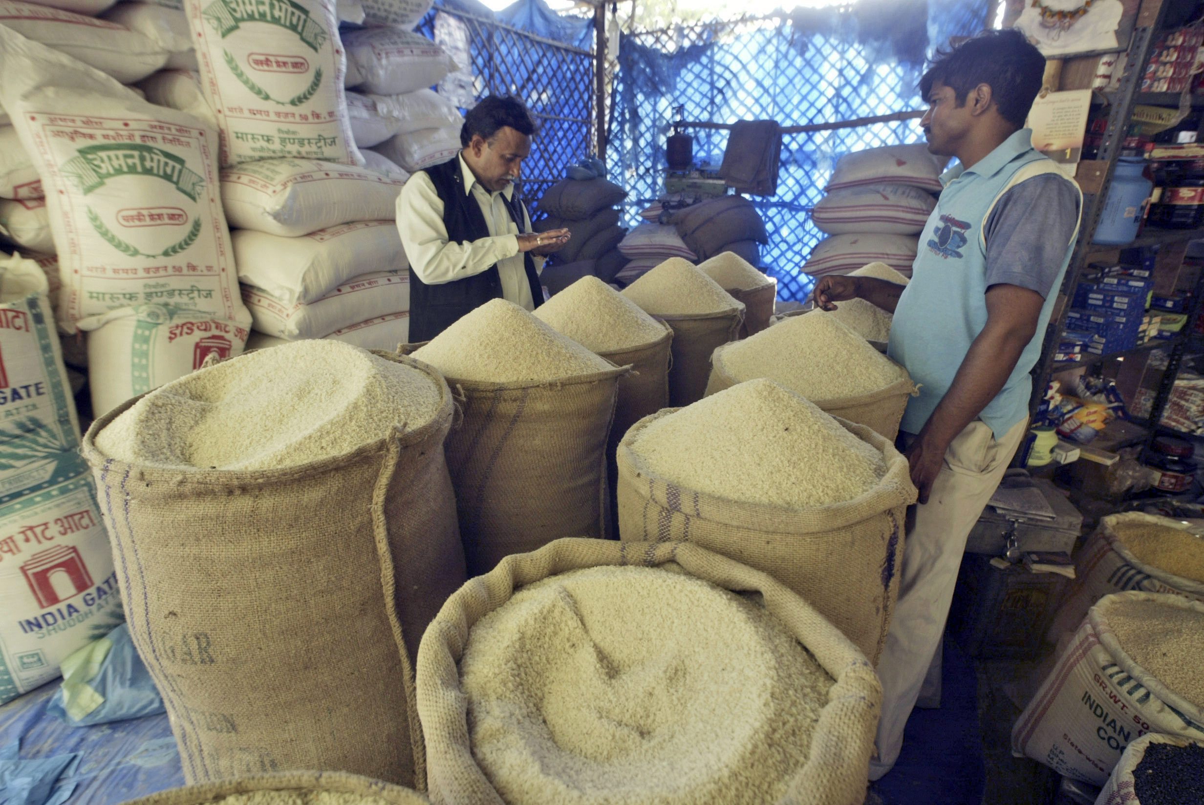 A customer buys rice at a market in Allahabad, India.