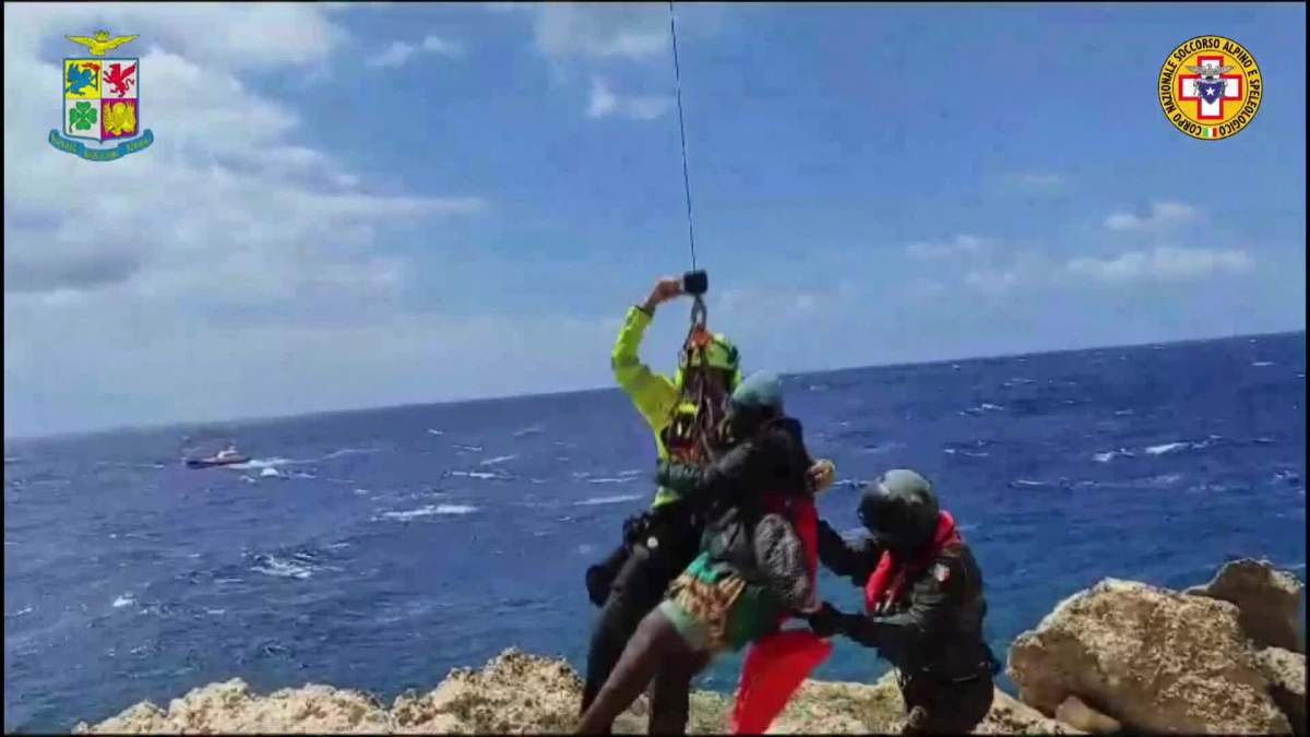 A migrant stranded on a rocky reef on the tiny Italian southern island of Lampedusa, Sicily is pluck to safety by helicopter.