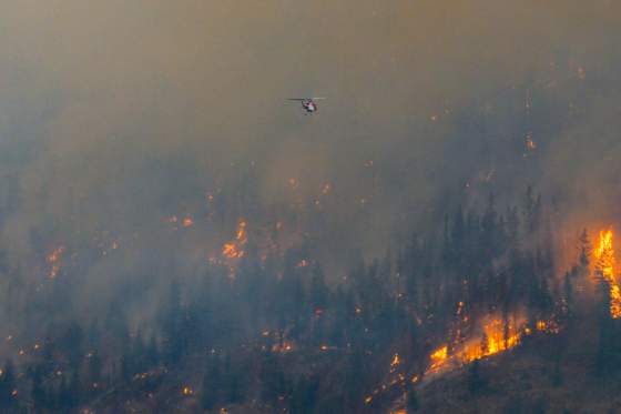 A helicopter works to contain the Lower East Adams fire burning roughly 21 kilometres north of Chase, B.C.