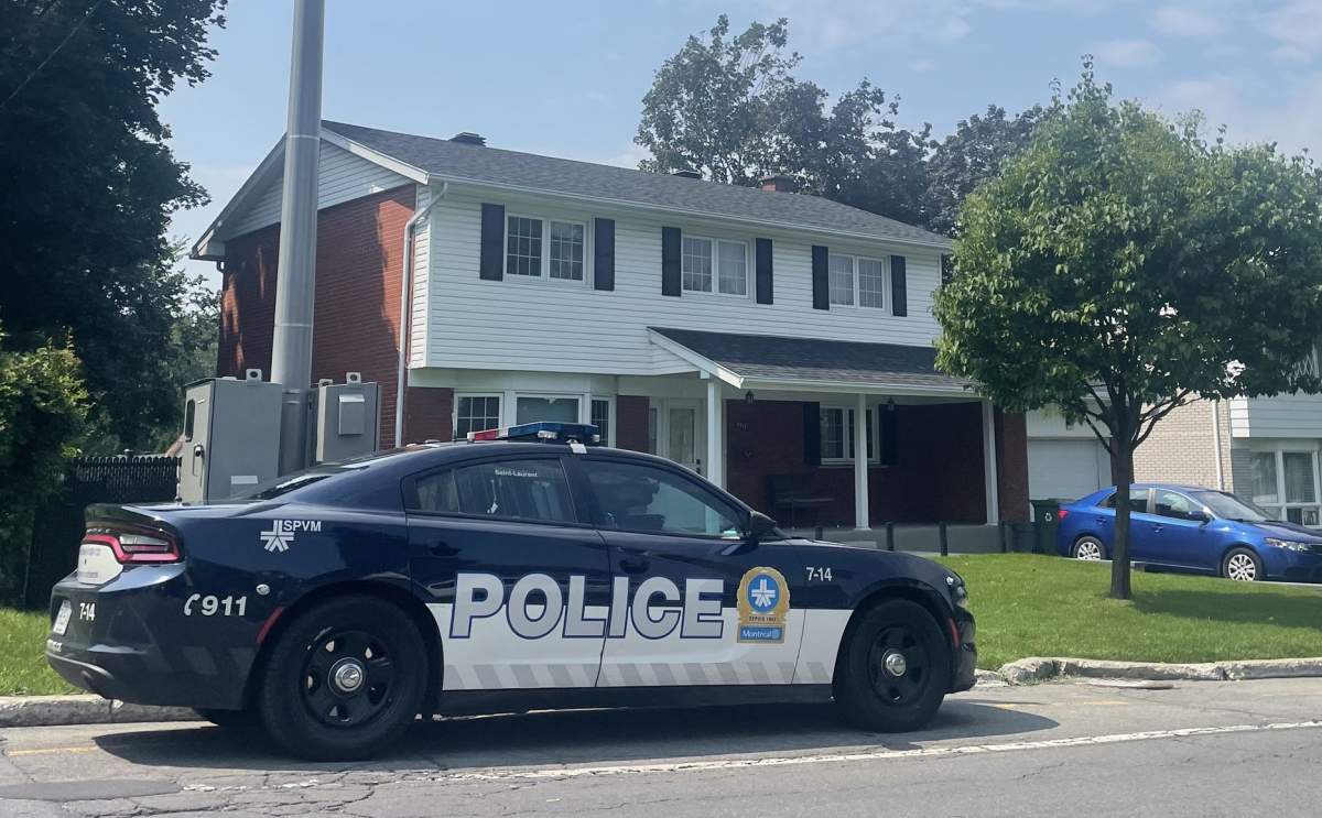A police vehicle is seen outside the Pierrefonds home of the 34-year-old victim and the 39-year-old suspect on Sunday. Neighbours say the couple has two young children.