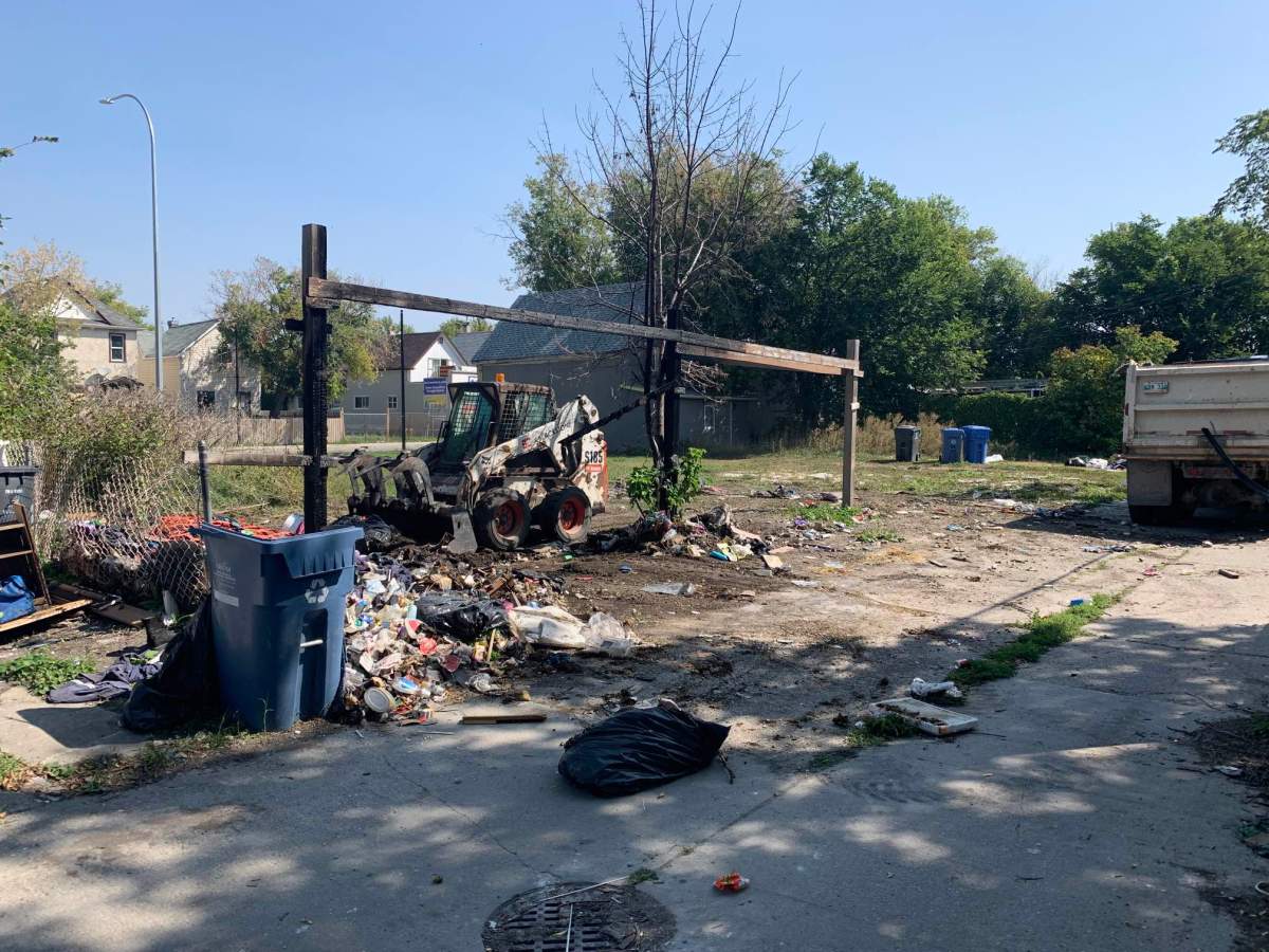 City crews clean up a long-standing garbage pile in the Burrows neighbourhood Wednesday.
