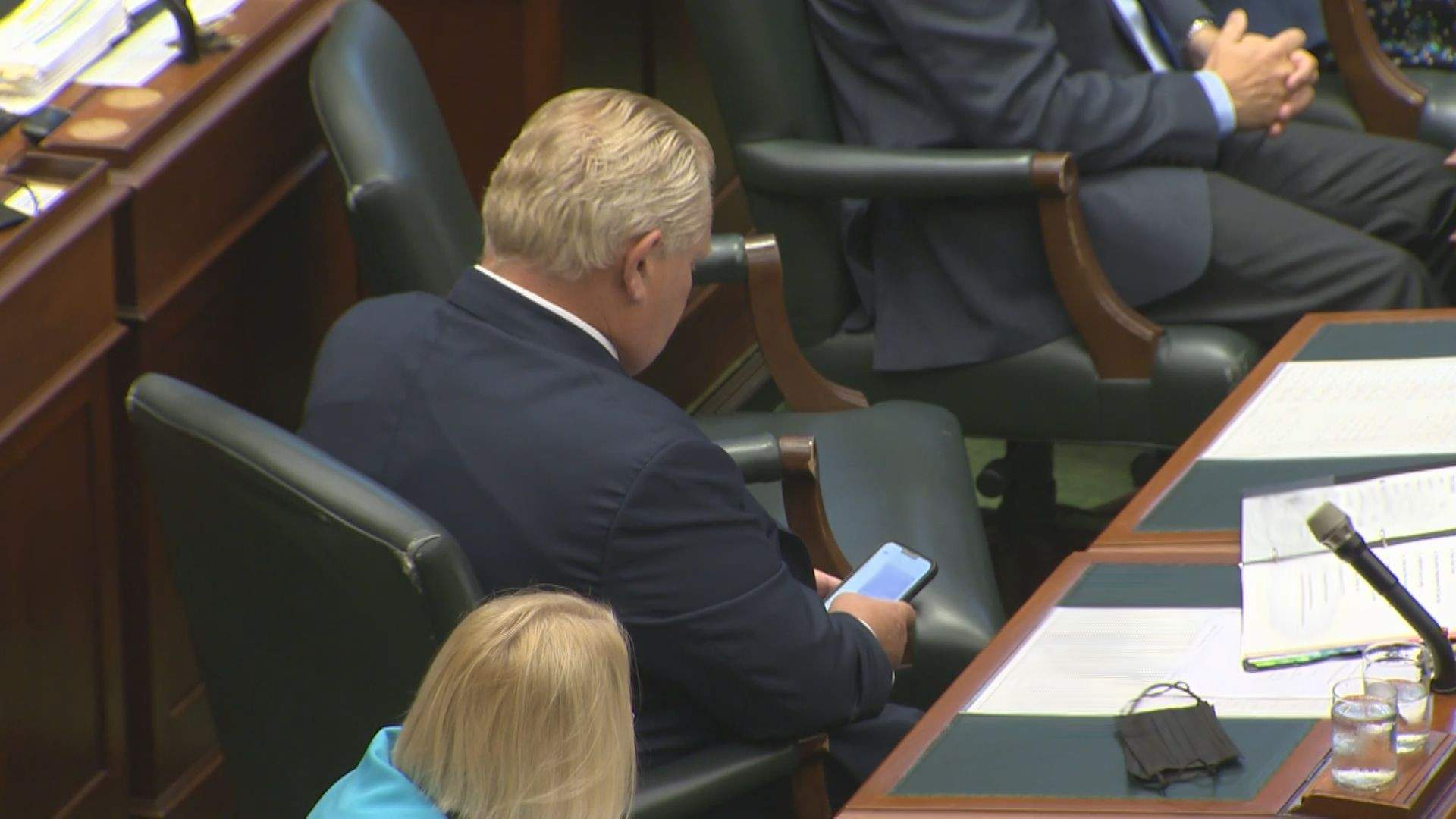 Ontario Premier Doug Ford looks at his cellphone inside the legislature.