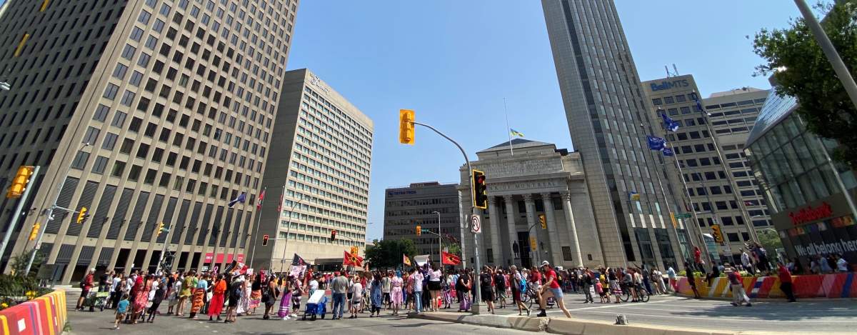 People gathered, wearing red and orange at a major intersection.