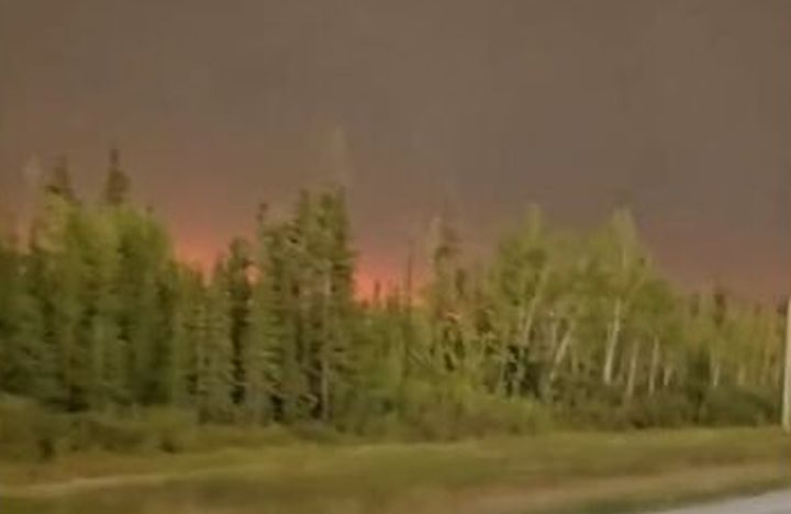 A photo of a glowing sky where wildfires are burning near the border between Alberta and the Northwest Territories.