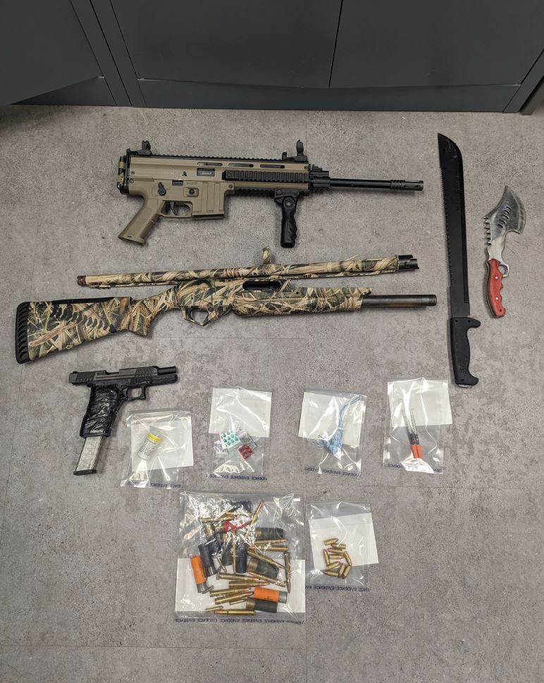 The raid led to the arrest of four people and the recovery of a loaded handgun, two additional firearms, a machete, ammunition and drugs.