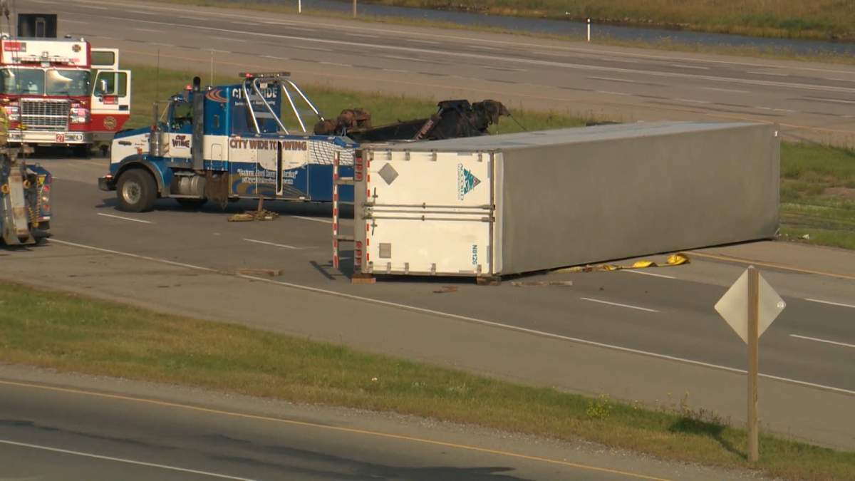 A tow truck next to a toppled semi tractor-trailer following a Friday morning crash on eastbound Stoney Trail near the Metis Trail exit.