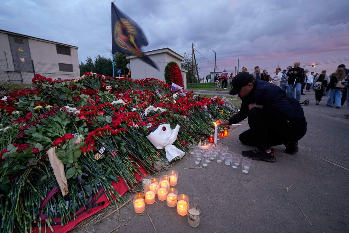 A man lights candles at a informal memorial next to the former ‘PMC Wagner Centre’ in St. Petersburg, Russia, Thursday, Aug. 24, 2023. Russia’s civil aviation agency says mercenary leader Yevgeny Prigozhin was aboard a plane that crashed north of Moscow. (AP Photo/Dmitri Lovetsky)