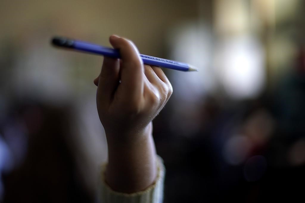 FILE - A student raises her hand to ask a question in her third grade classroom at Highland Elementary School in Columbus, Kan., on Monday, Oct. 17, 2022. S(AP Photo/Charlie Riedel, File).