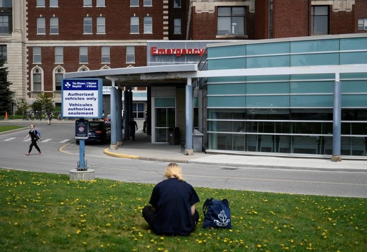 Some eastern Ontario hospitals are bringing back mask requirements in patient-care areas as the respiratory virus season approaches. A person rests on a lawn outside the Emergency Department entrance at the Ottawa Hospital Civic Campus in Ottawa is shown on Monday, May 16, 2022. 