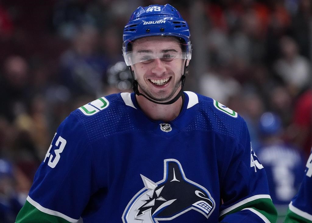 Vancouver Canucks’ Quinn Hughes smiles before a faceoff against the Seattle Kraken during the game in Vancouver on Sept. 29, 2022.