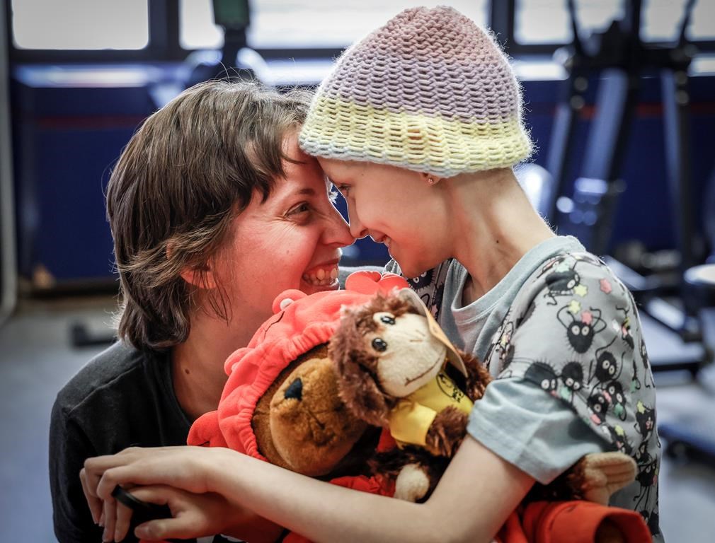 Bridget Penney, left, and her daughter Mira Penney, 10, share a moment while taking part in an exercise session that helps kids to stay active during cancer care, in Calgary, Sept. 12, 2023.