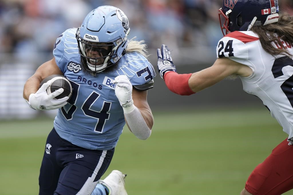 Toronto Argonauts running back A.J. Ouellette (34) is chased by Montreal Alouettes defensive back Marc-Antoine Dequoy (24) during second half CFL football action in Toronto, Saturday, Sept. 9, 2023. The Argonauts can clinch top spot in the Canadian Football League’s East Division with a win Friday over the host Montreal Alouettes. THE CANADIAN PRESS/Arlyn McAdorey.