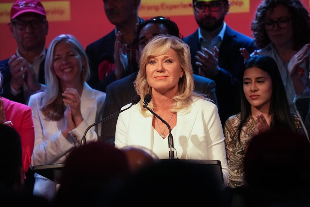 Mississauga mayor and provincial Liberal leadership candidate Bonnie Crombie stands on stage with supporters at a rally in Mississauga, Ont., on June 14. A health-care policy document obtained by Global News shows that if elected premier, she would increase the minimum wage for nurses and personal support workers.