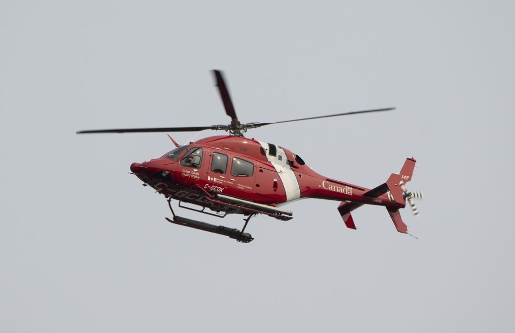 Quebec provincial police say three people are dead after a fishing boat sunk off the province's Lower North Shore. A Coast Guard helicopter flies over the port of St. John’s on Saturday, June 24, 2023.