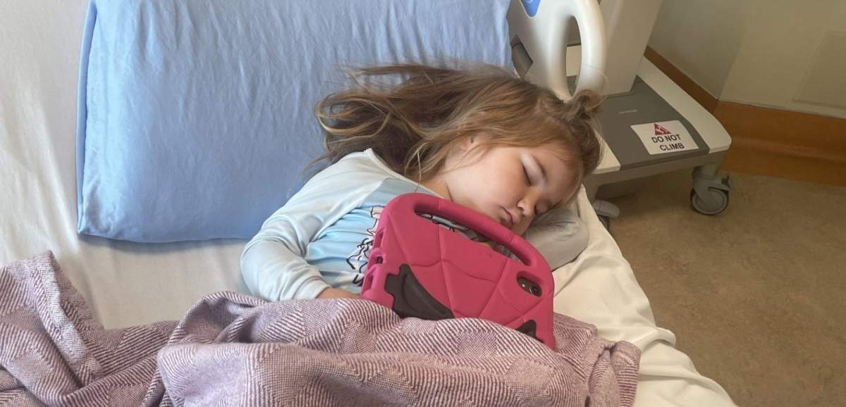 Amelia Leonard, one of more than 100 children impacted by a daycare E. coli outbreak, sleeps in a bed at the Alberta Children's Hospital.