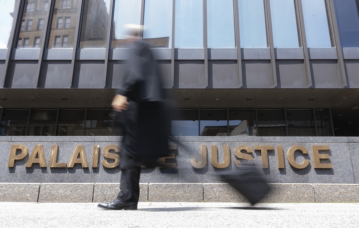 The unnamed informant at the heart of Quebec's so-called secret trial is suing authorities for more than $5.7 million for compensatory and punitive damages. A lawyer walks past the courthouse in Montreal, Wednesday, July 12, 2023. 