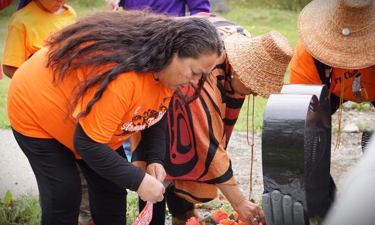 Haisla Nation survivors lay flags at a memorial for children who attended residential school in Kitimaat, B.C. on National Day for Truth and Reconciliation.