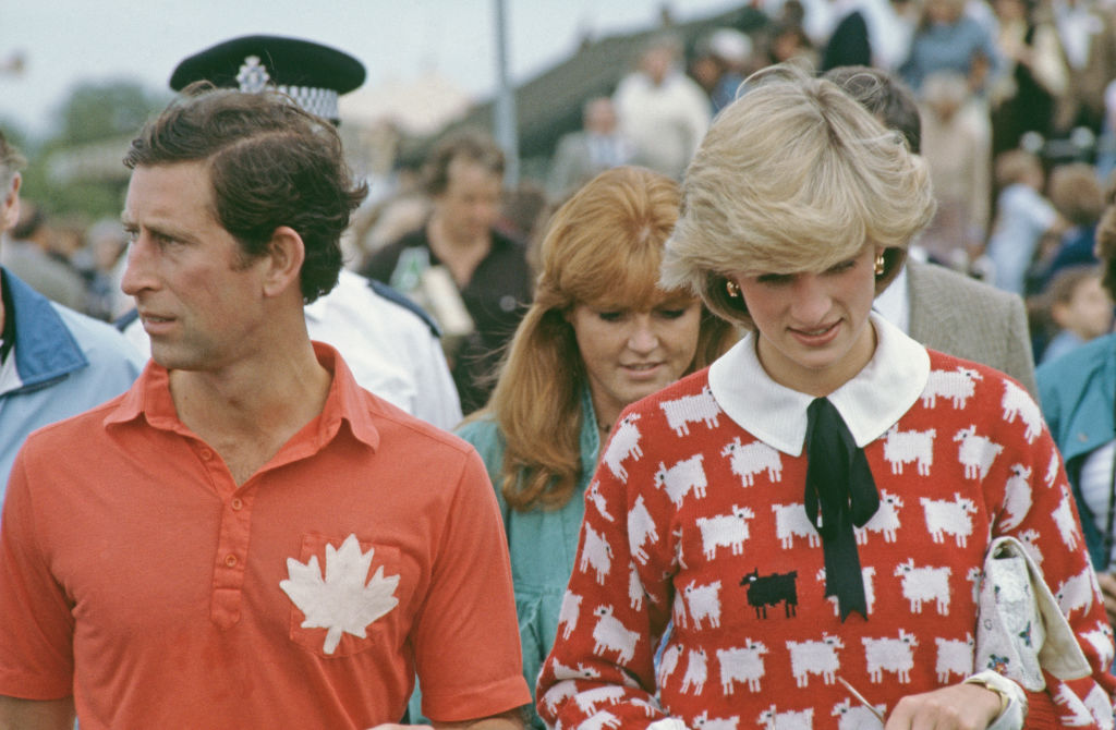 Diana, Princess of Wales, Prince Charles and Sarah Ferguson attend a polo match at Smith's Lawn, Guards Polo Club, Windsor, June 1983. Diana is wearing a Muir and Osborne 'black sheep' sweater.