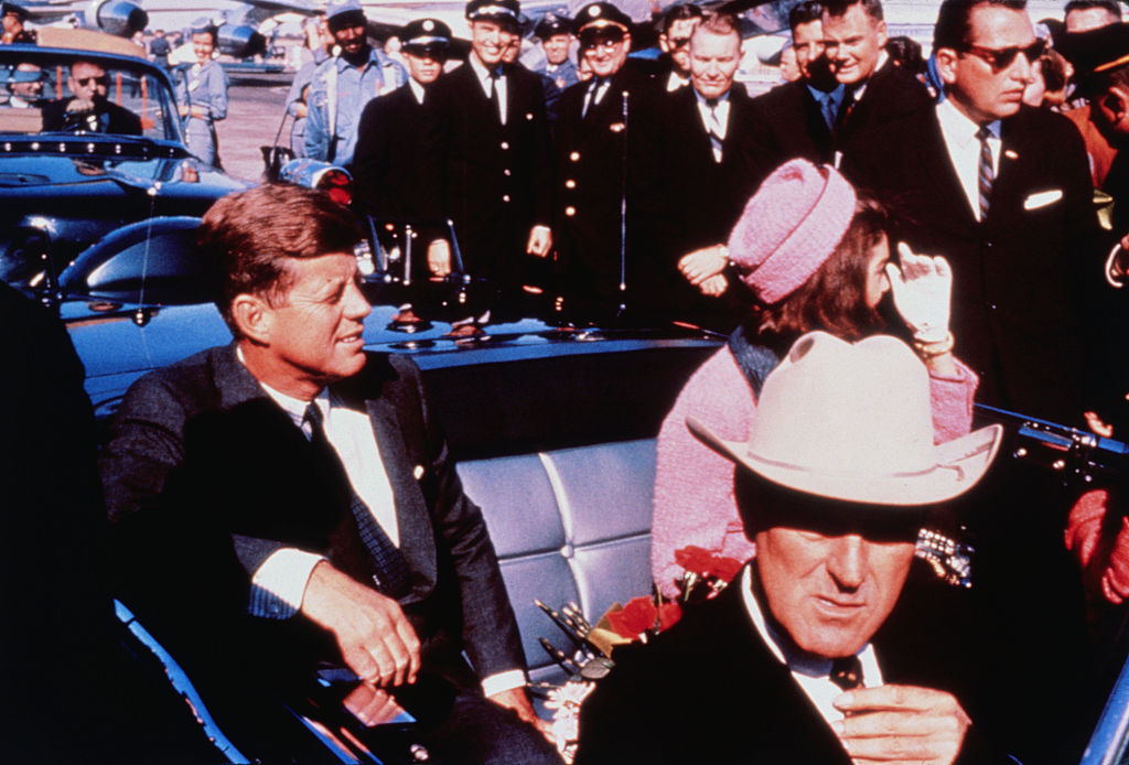 U.S. President John F. Kennedy (left) and First Lady Jacqueline Kennedy are settled in rear seats, prepared for the motorcade into Dallas from the airport, Nov. 22, 1963.