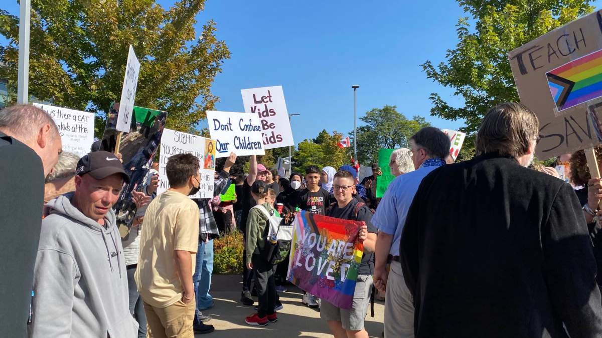 Protestors and counter-protestors holding signs in Hamilton, Ont.