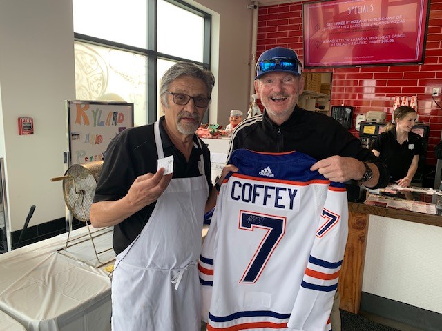 Peter Giannakopoulos, owner of Nitza's Pizzas in Sherwood Park, holds up a Paul Coffey jersey for auction. Sept. 4, 2023.