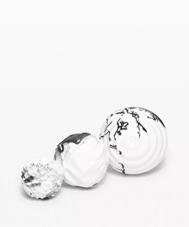 Three white and black massage balls in a big, medium and small size