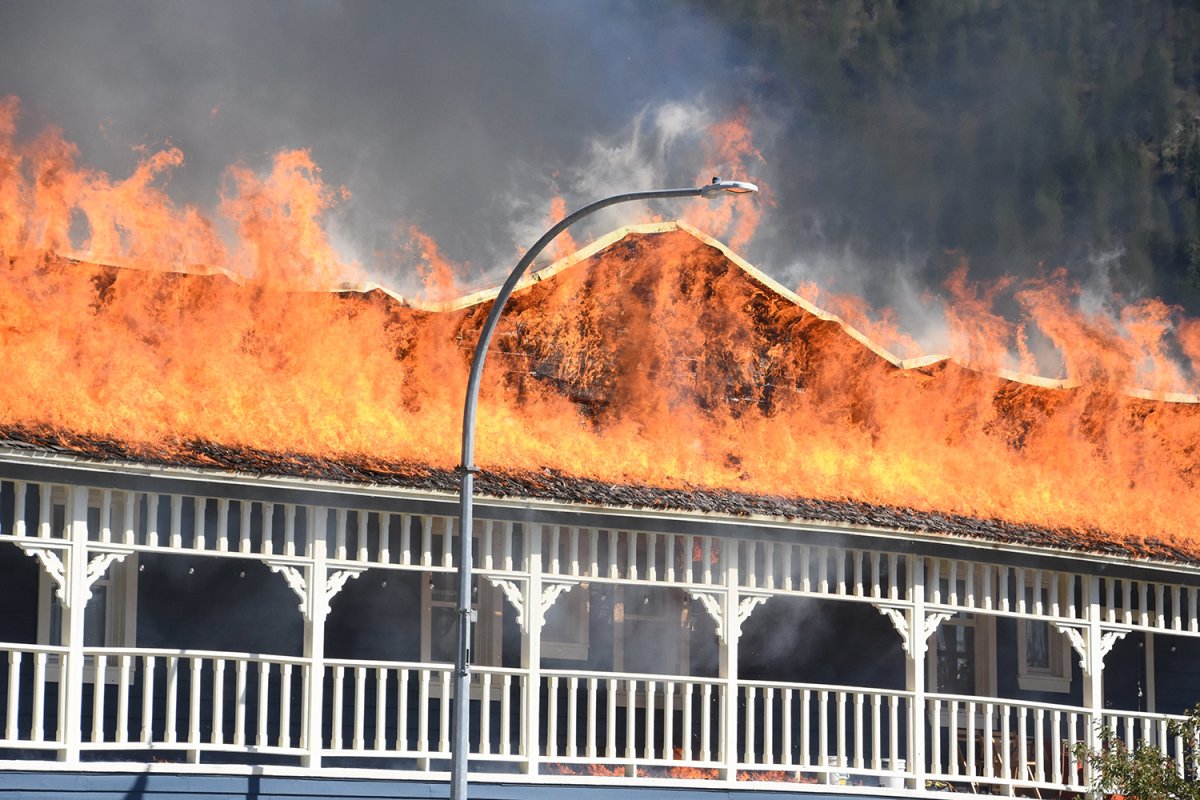 Flames burn the roof of the Salmo Hotel on Friday afternoon.
