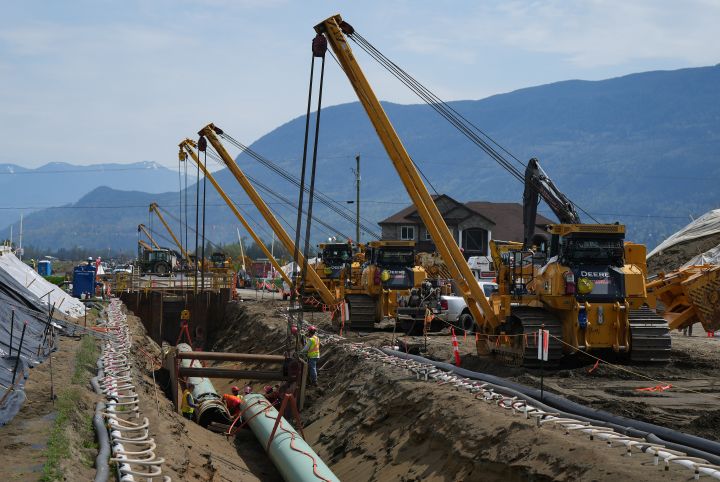 Workers lay pipe during construction of the Trans Mountain pipeline expansion on farmland, in Abbotsford, B.C., on Wednesday, May 3, 2023.